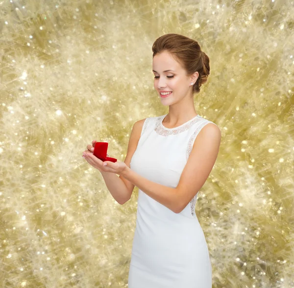 Donna sorridente in possesso di scatola regalo rossa con anello — Foto Stock