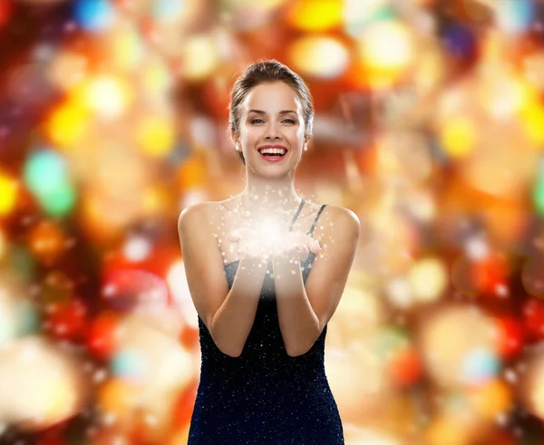 Laughing woman in evening dress holding something — Stock Photo, Image