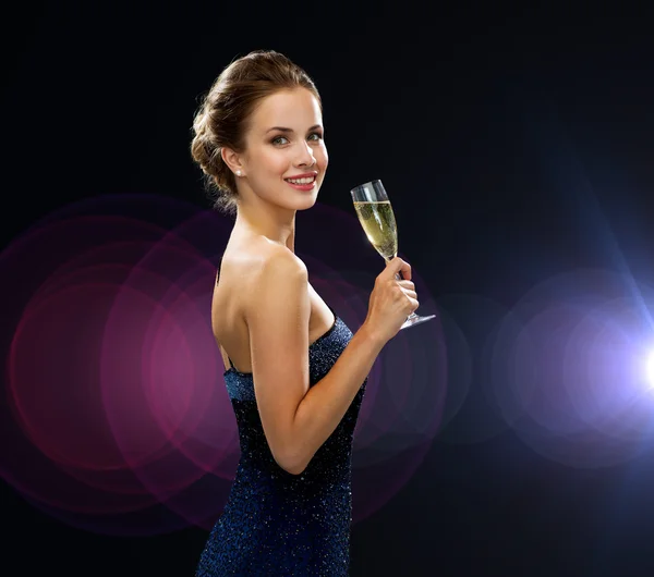 Sonriente mujer sosteniendo un vaso de vino espumoso — Foto de Stock