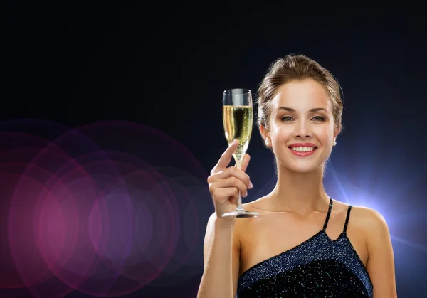 Sonriente mujer sosteniendo un vaso de vino espumoso —  Fotos de Stock