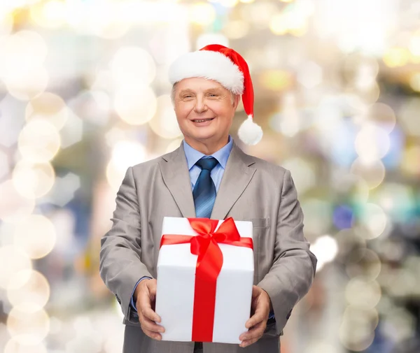 Glimlachende man in pak en santa helper hoed met cadeau — Stockfoto