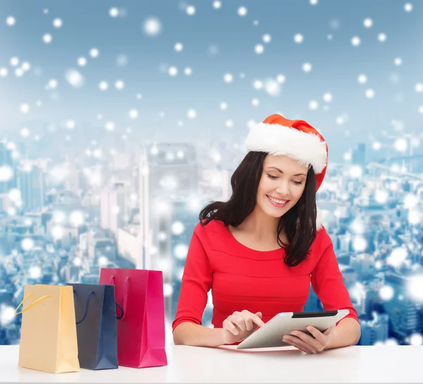 Smiling woman with shopping bags and tablet pc — Stock Photo, Image