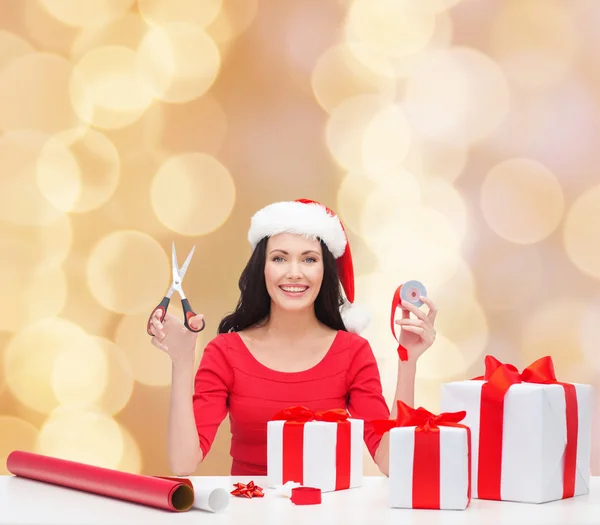 Lachende vrouw in helper KERSTMUTS verpakking geschenken — Stockfoto