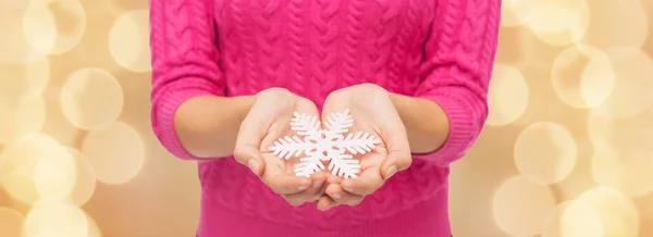 Close up de mulher em suéter segurando floco de neve — Fotografia de Stock