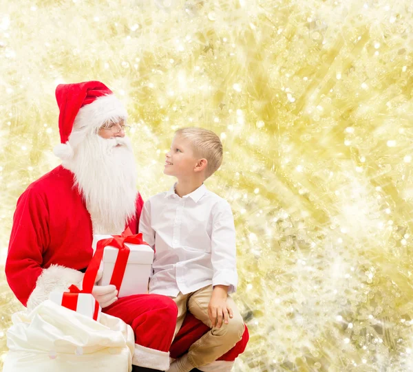 Lachende jongetje met santa claus en giften — Stockfoto