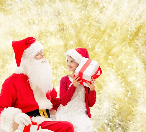 Leende liten flicka med jultomten och gåvor — Stockfoto