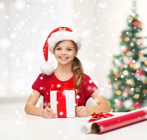 Lachende meisje in helper kerstmuts met een doos van de gift — Stockfoto