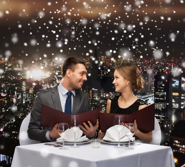 Smiling couple with menus at restaurant — Stock Photo, Image