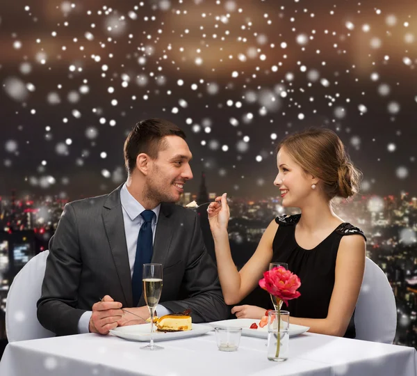 Smiling couple eating dessert at restaurant — Stock Photo, Image