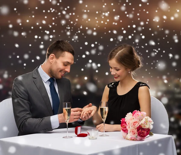 Casal sorridente com caixa de presente vermelho no restaurante — Fotografia de Stock