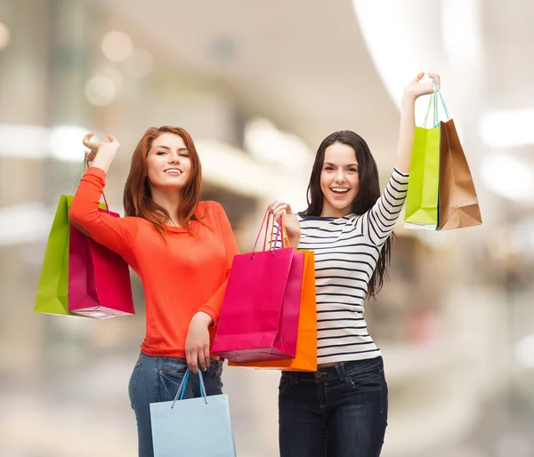 Twee glimlachend tienermeisjes met shopping tassen — Stockfoto