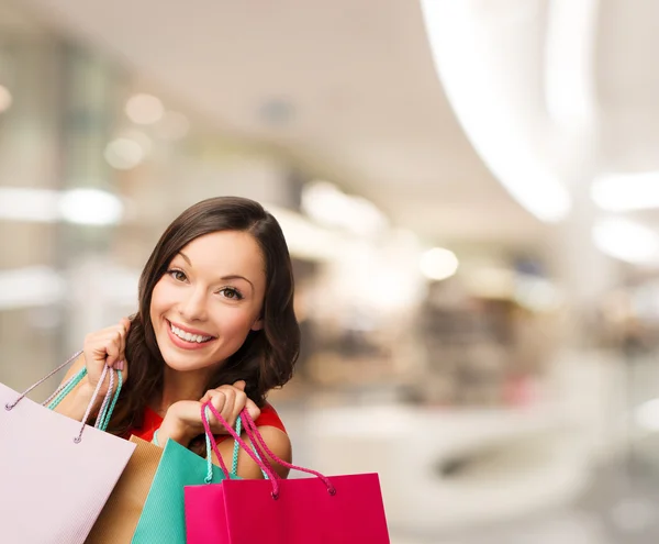 Lachende jonge vrouw met shopping tassen — Stockfoto