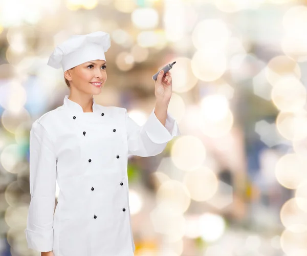 Sorrindo chef feminino escrevendo algo no ar — Fotografia de Stock