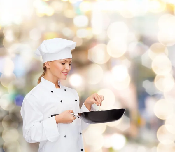 Chef feminino sorridente com panela e colher — Fotografia de Stock