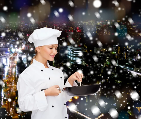 Smiling female chef with pan and spoon — Stock Photo, Image