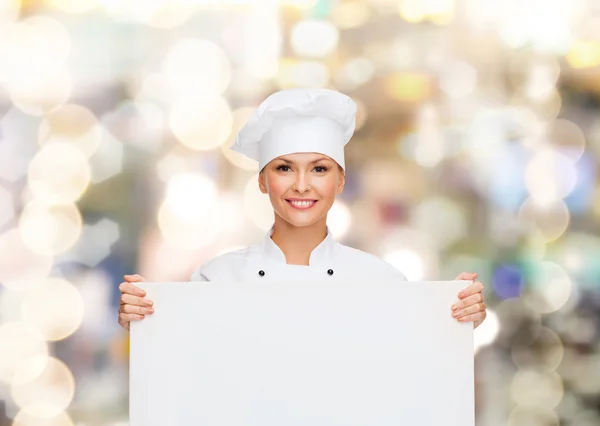 Smiling female chef with white blank board — ストック写真