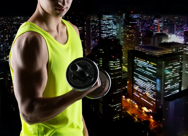 Close up of young man with dumbbell flexing biceps — Stock Photo, Image