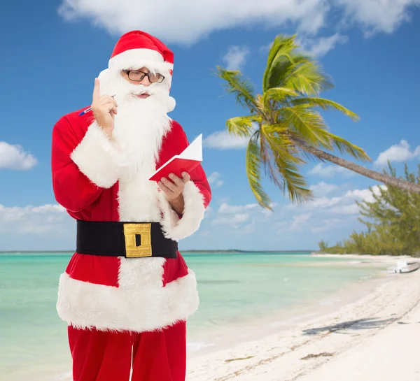 Man in costume of santa claus with notepad — Stock Photo, Image