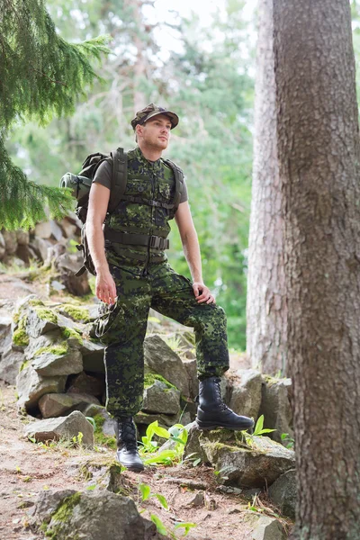 Young soldier with backpack in forest — Stock Photo, Image