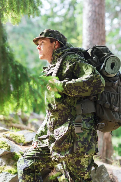 Ung soldat med ryggsäck i skogen — Stockfoto