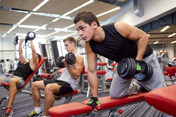 Groupe d'hommes avec haltères dans la salle de gym — Photo