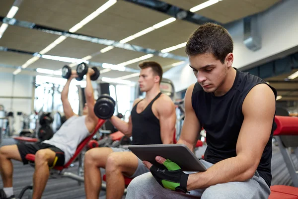 Grupp män med TabletPC och hantlar i gym — Stockfoto