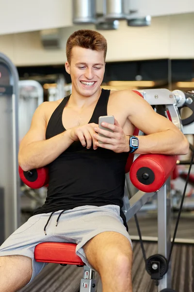 Jovem sorridente com smartphone no ginásio — Fotografia de Stock