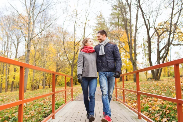 Uśmiechający się para przytulanie na most w parku jesień — Zdjęcie stockowe