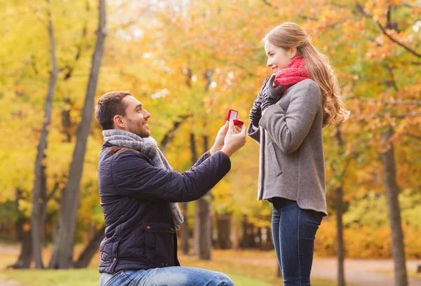 Smiling couple with engagement ring in gift box — Stock Photo, Image