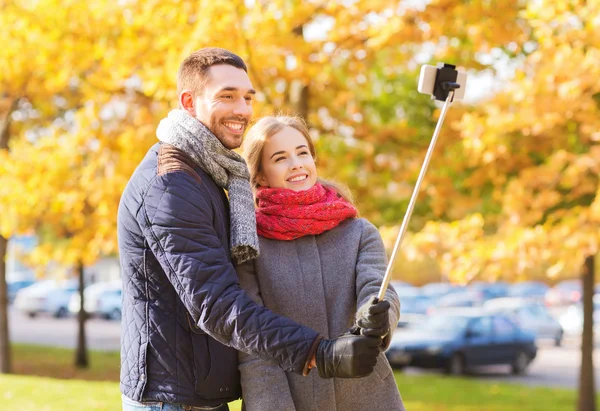 Lachende paar met smartphone in herfst park — Stockfoto
