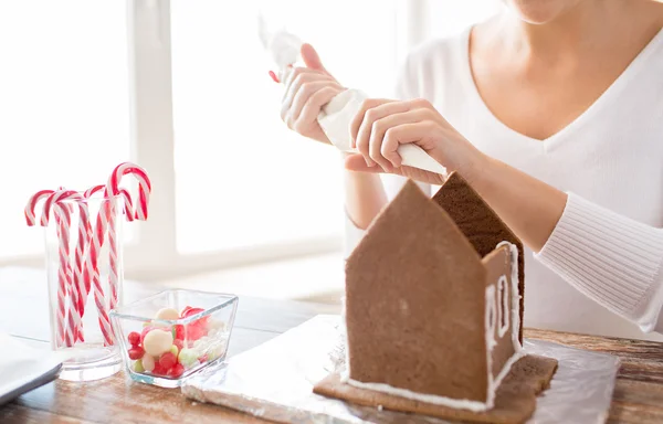 Primo piano di donna che fa case di pan di zenzero — Foto Stock