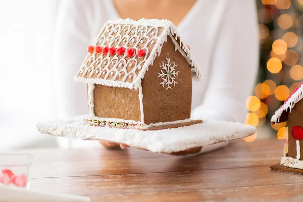 Kadın gösteren gingerbread evi yakın çekim — Stok fotoğraf