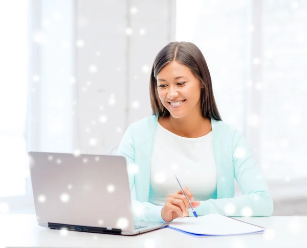 Giovane donna sorridente con computer portatile e notebook — Foto Stock