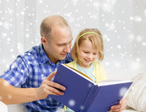 Sorridente padre e figlia con libro a casa — Foto Stock