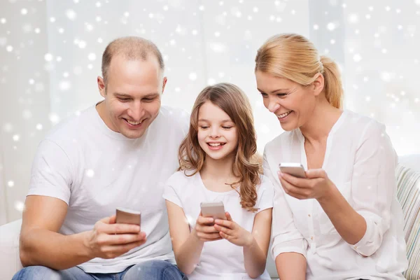 Lycklig familj med smartphones hemma — Stockfoto