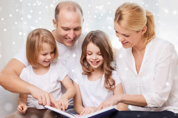 Família feliz com livro em casa — Fotografia de Stock