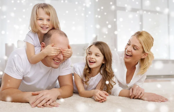 Padres sonrientes y dos niñas en casa — Foto de Stock