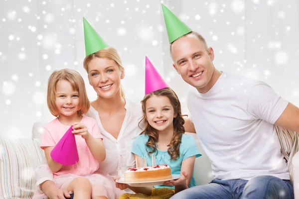 Famille heureuse avec deux enfants dans des chapeaux de fête à la maison — Photo