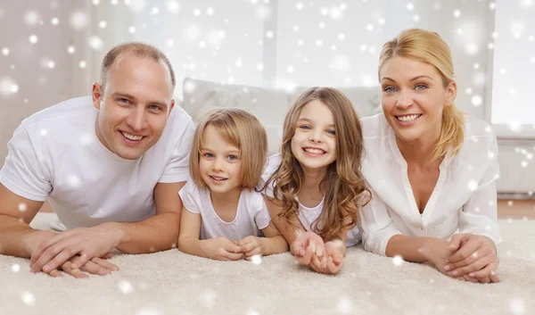 Padres sonrientes y dos niñas en casa Fotos De Stock