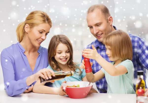 Gelukkige familie met twee kinderen maken salade thuis — Stockfoto