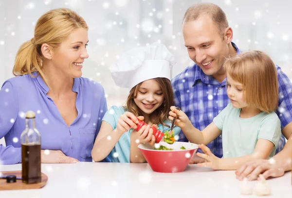 Glückliche Familie mit zwei Kindern, die zu Hause Salat zubereiten — Stockfoto