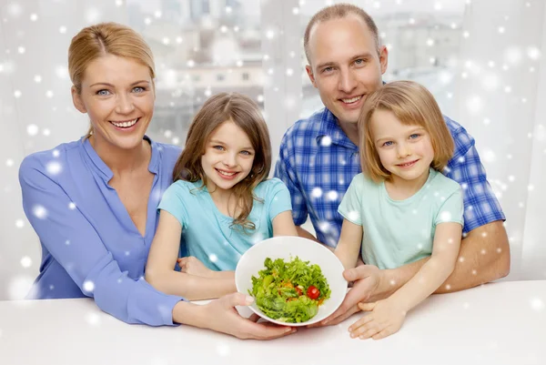 Lycklig familj med två barn visar sallad i skål — Stockfoto