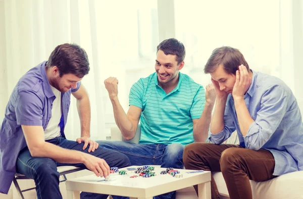 Feliz tres amigos masculinos jugando póquer en casa —  Fotos de Stock