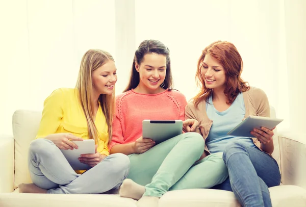 Три улыбающиеся девочки-подростка с планшетным компьютером дома — стоковое фото