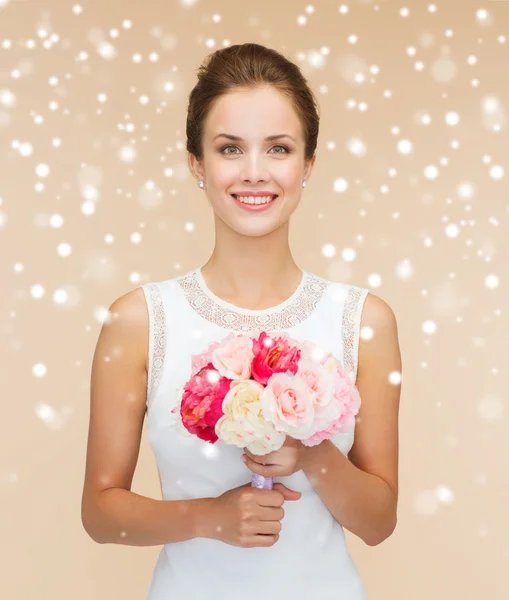 Lächelnde Frau im weißen Kleid mit Blumen — Stockfoto