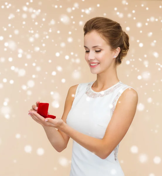 Smiling woman holding red gift box with ring — Stock Photo, Image