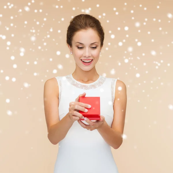 Sorrindo mulher segurando caixa de presente vermelho — Fotografia de Stock