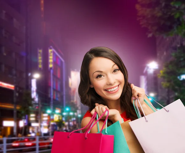 Sorrindo jovem mulher com sacos de compras — Fotografia de Stock