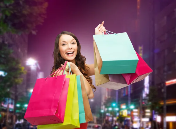 Sonriente joven con bolsas de compras —  Fotos de Stock