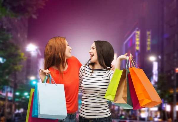 Twee glimlachend tienermeisjes met shopping tassen — Stockfoto